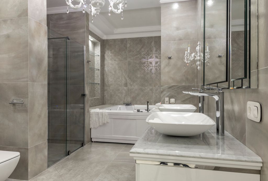 Luxurious and spacious bathroom with tiled walls and floor double vessel sink vanity and chandelier
